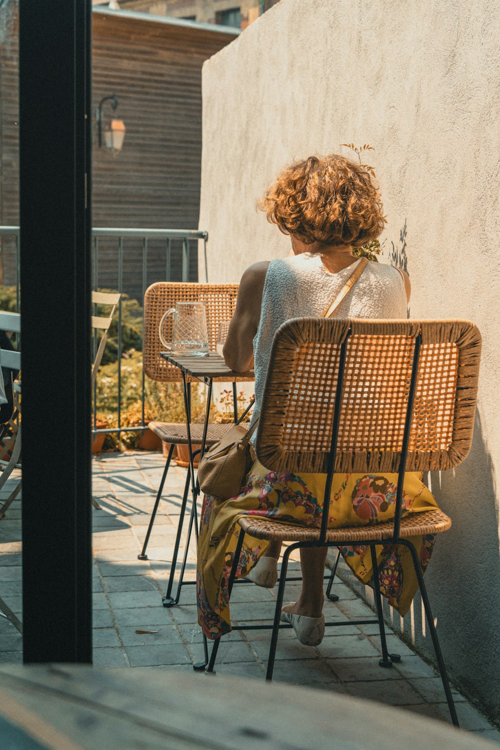 a woman sitting at a table on a patio