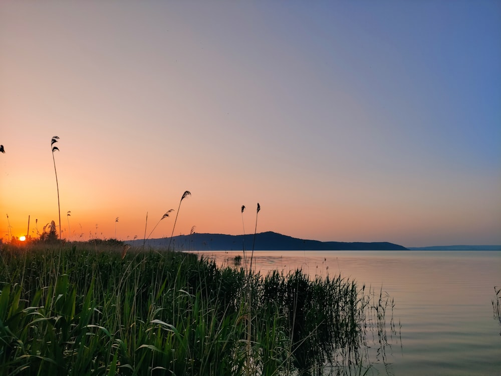 the sun is setting over a body of water