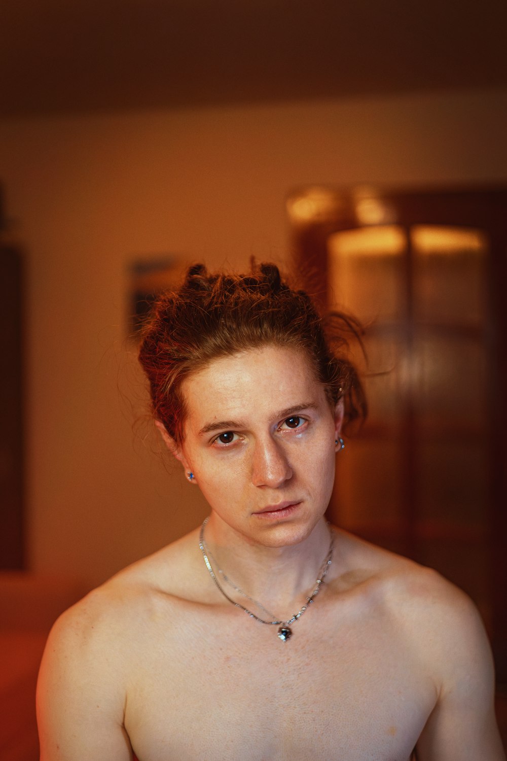 a shirtless woman with a necklace on her neck