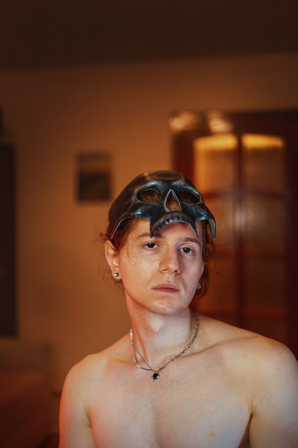 a shirtless man wearing a helmet in a room