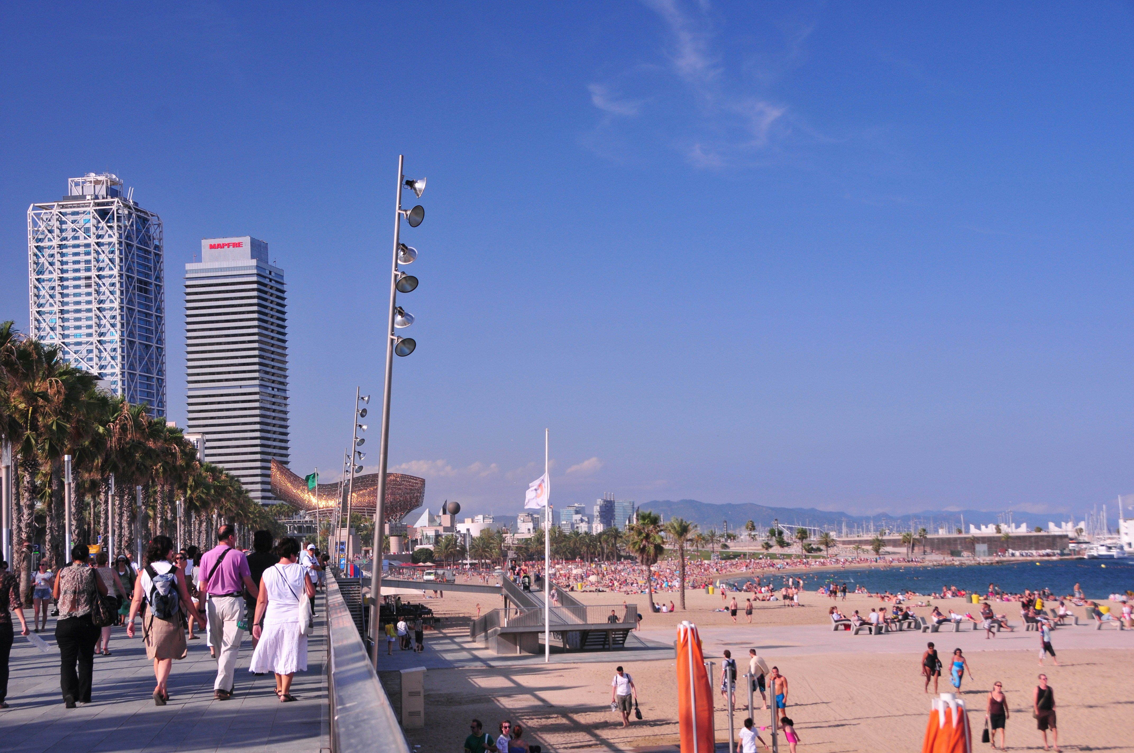 many people are walking on the beach near the water