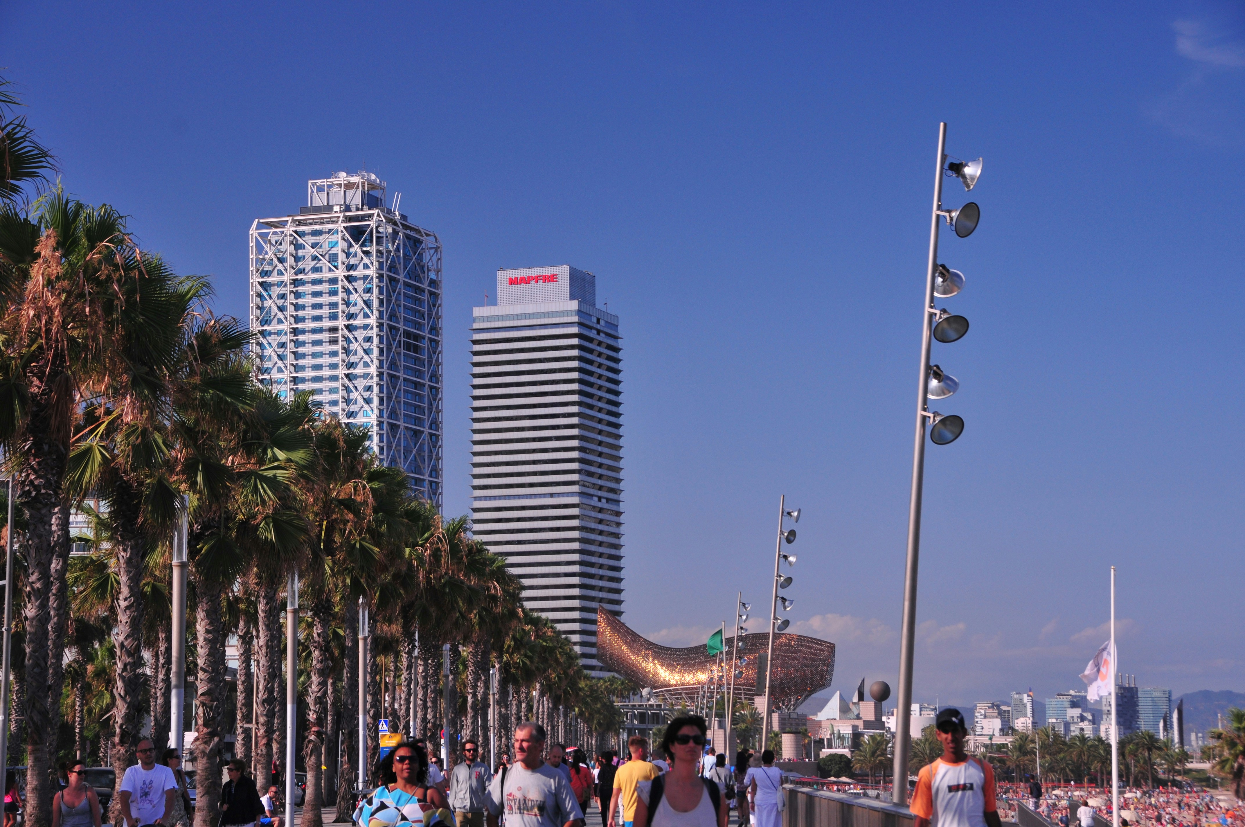 a group of people walking down a street next to tall buildings