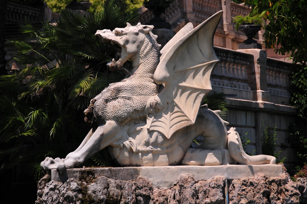 a statue of a dragon sitting on top of a rock