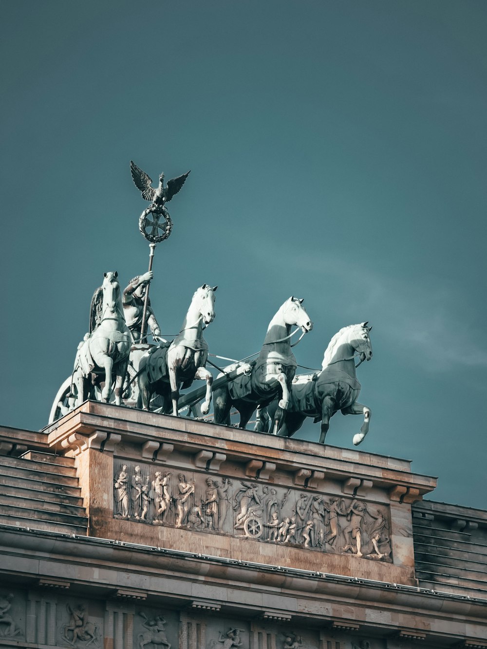 eine Statue von vier Pferden auf dem Dach eines Gebäudes