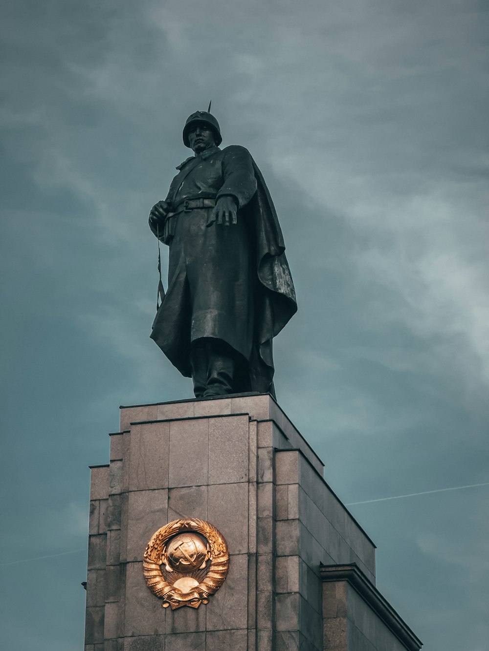 une statue d’un homme au sommet d’un bâtiment