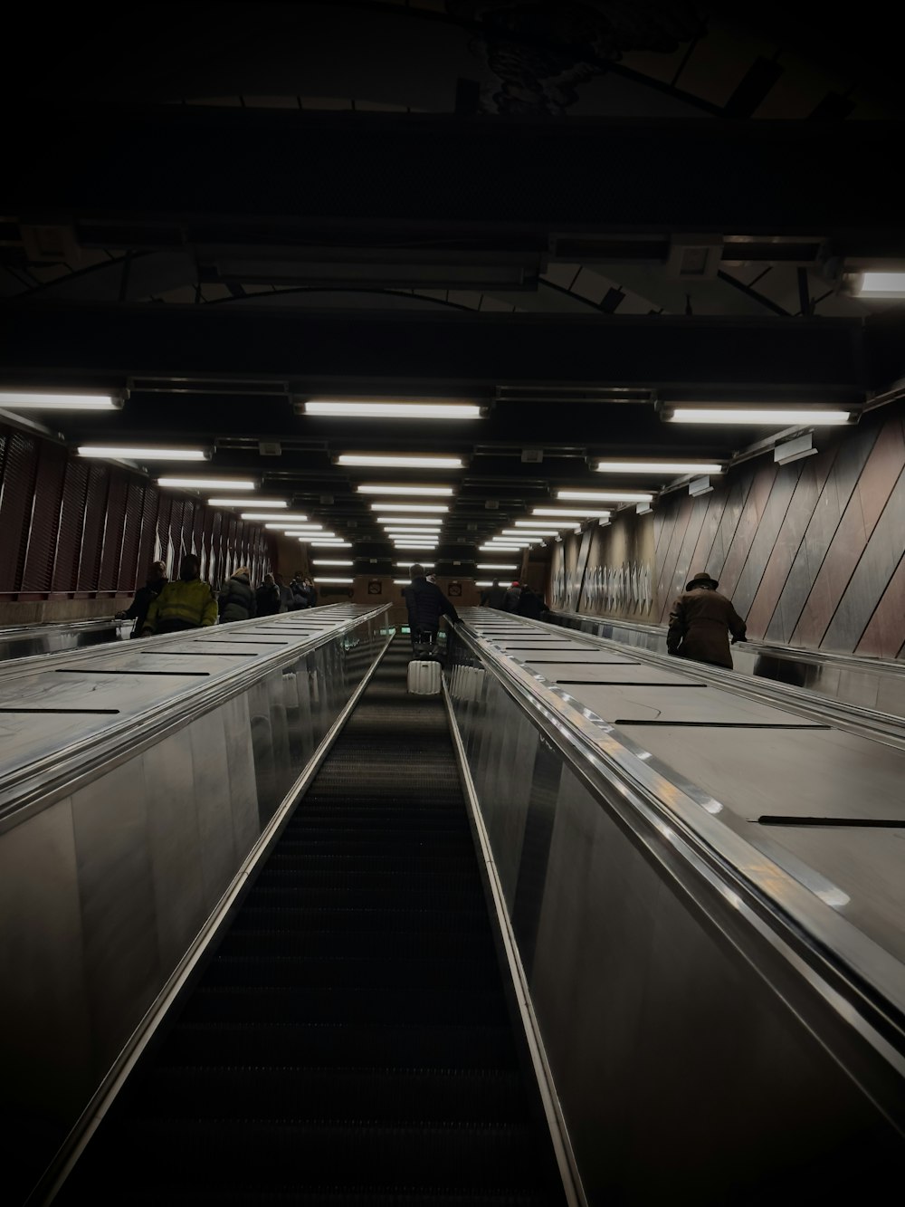 an empty subway station with people on the escalator
