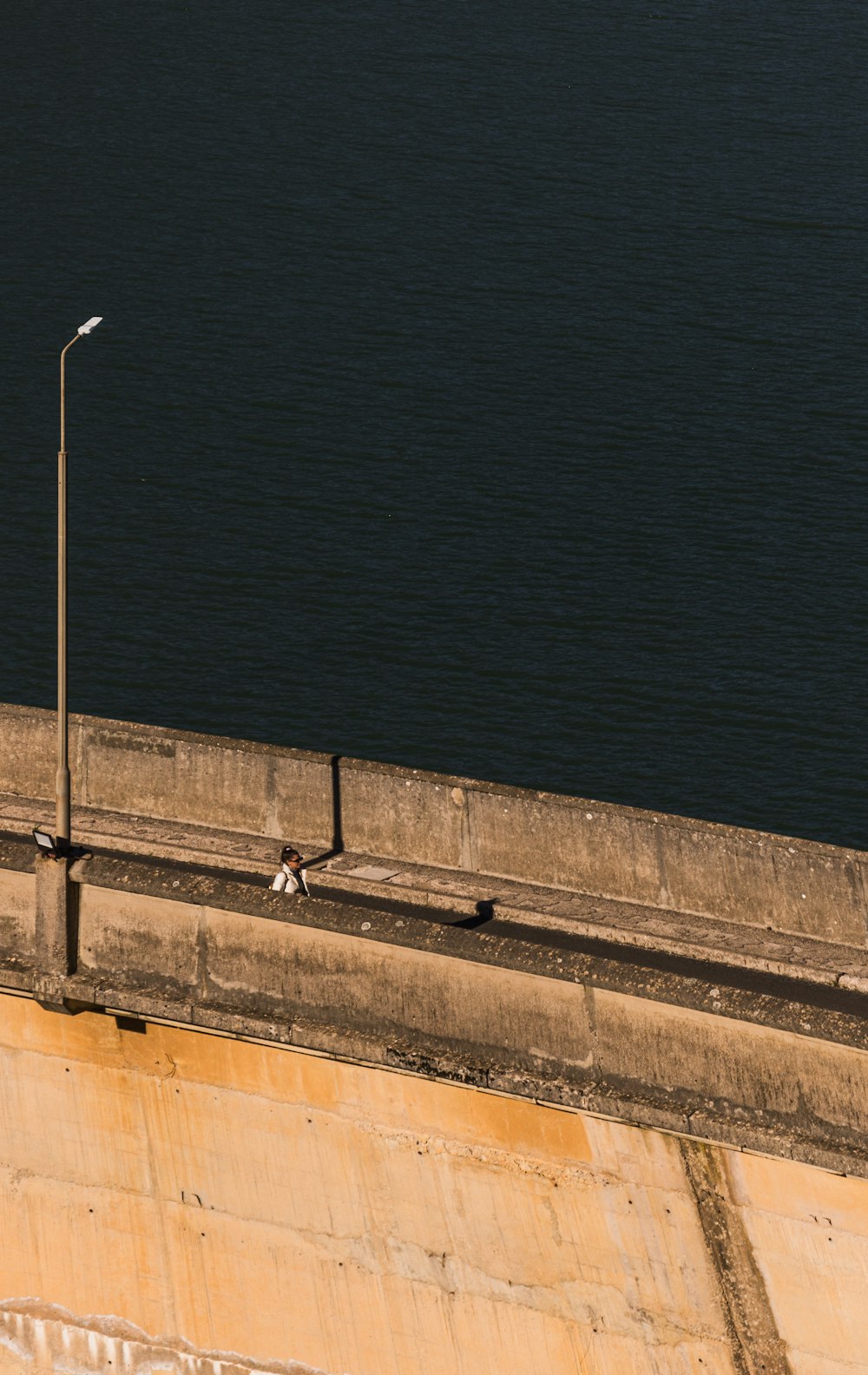 a couple of birds sitting on the side of a bridge