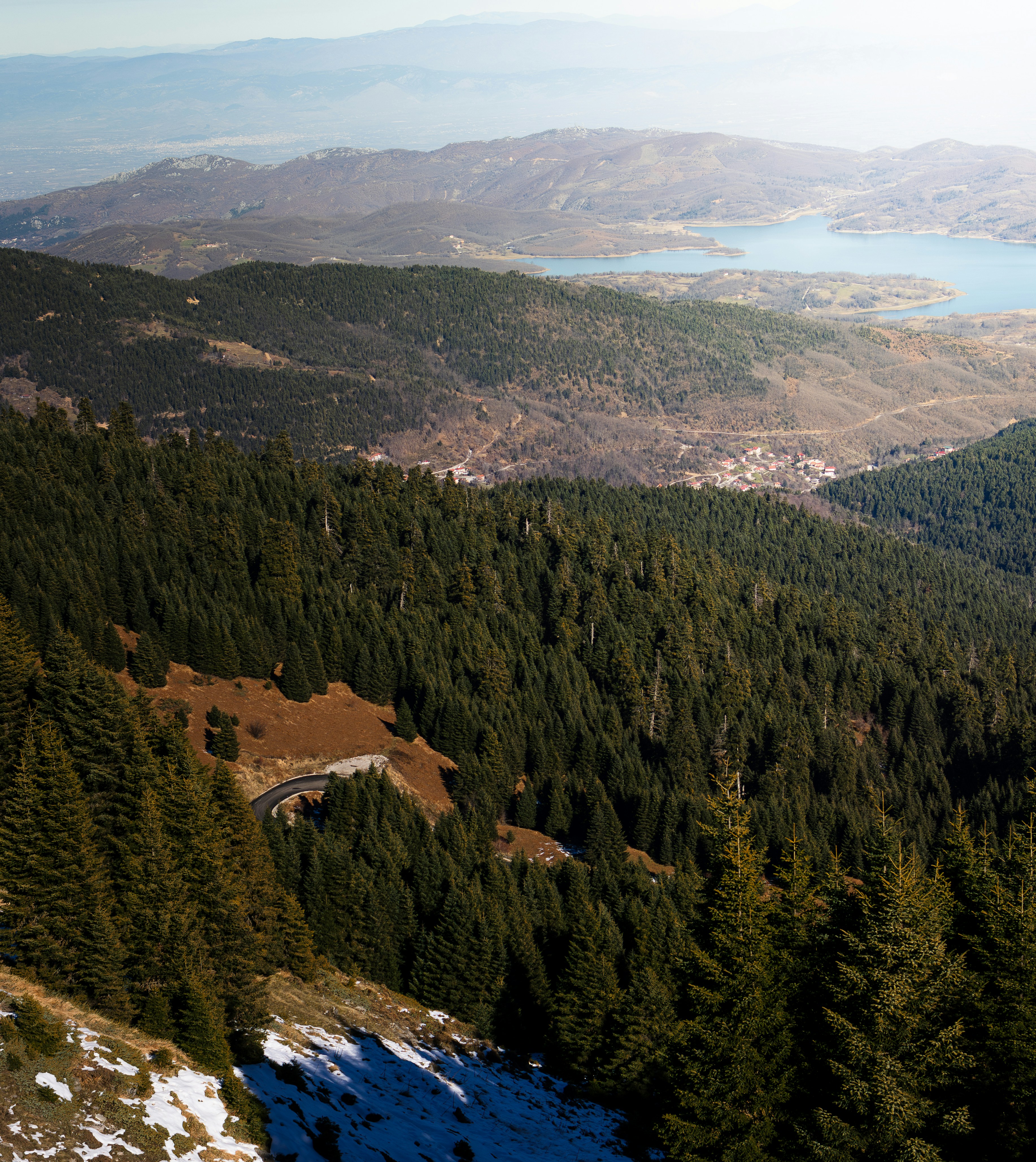 a scenic view of a mountain with a lake in the distance