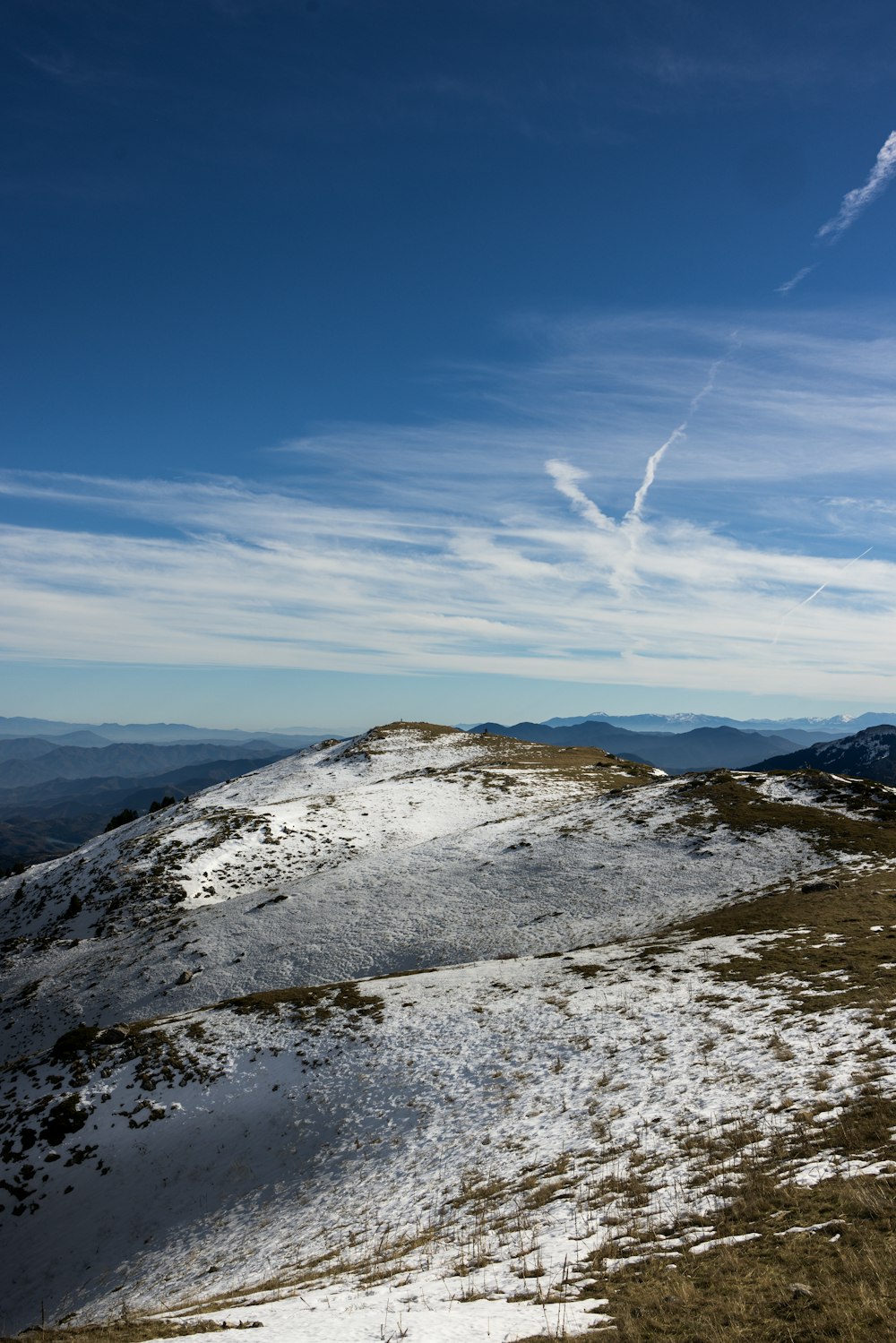 a snow covered hill with a blue sky in the background