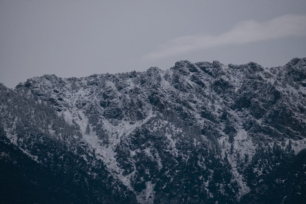 a mountain covered in snow with a sky background