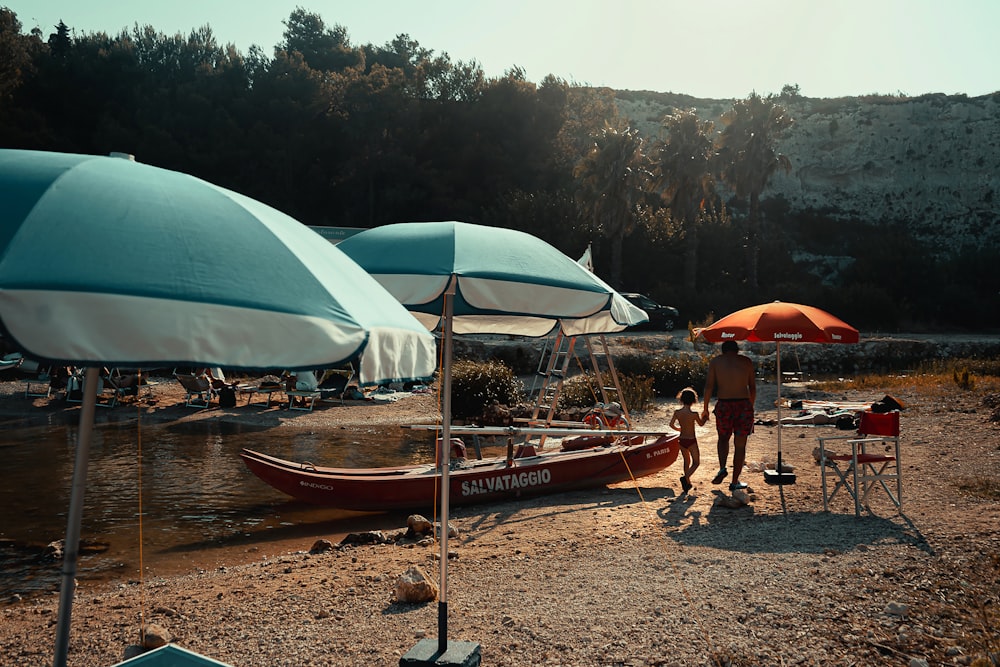 a man standing next to a boat on top of a lake