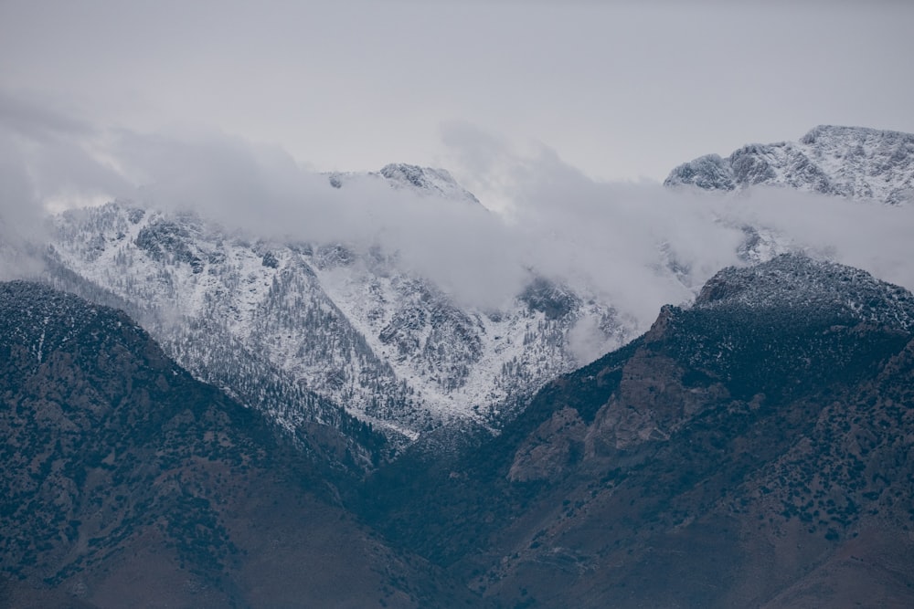 a mountain range covered in snow and clouds