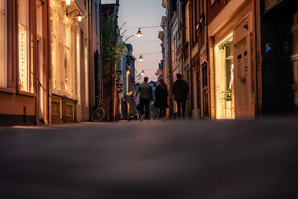 Un grupo de personas caminando por una calle junto a edificios altos