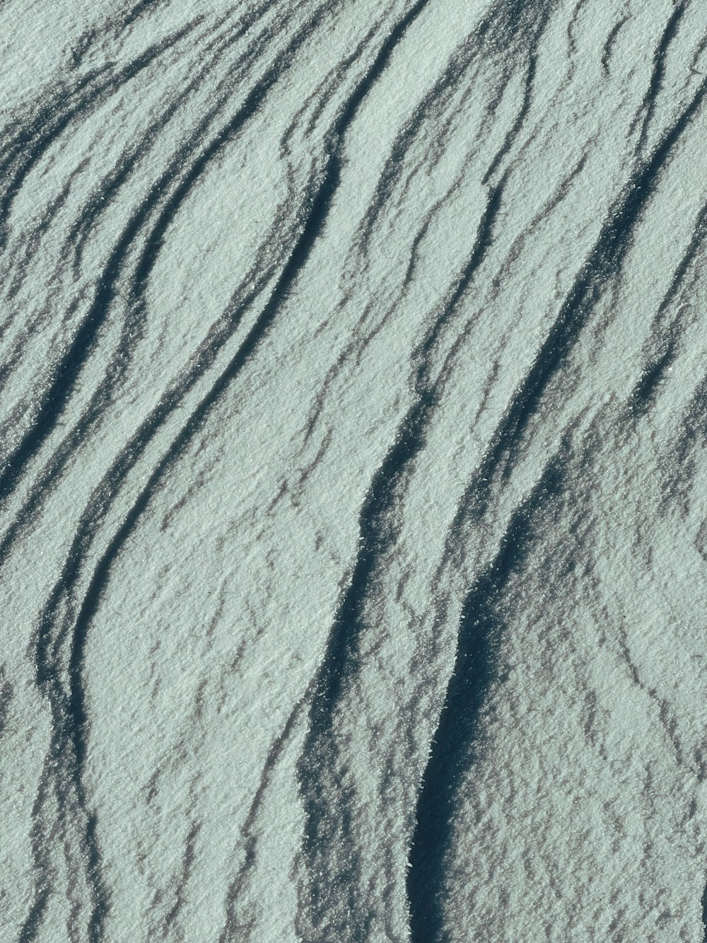 a snow covered ground with lines in the snow