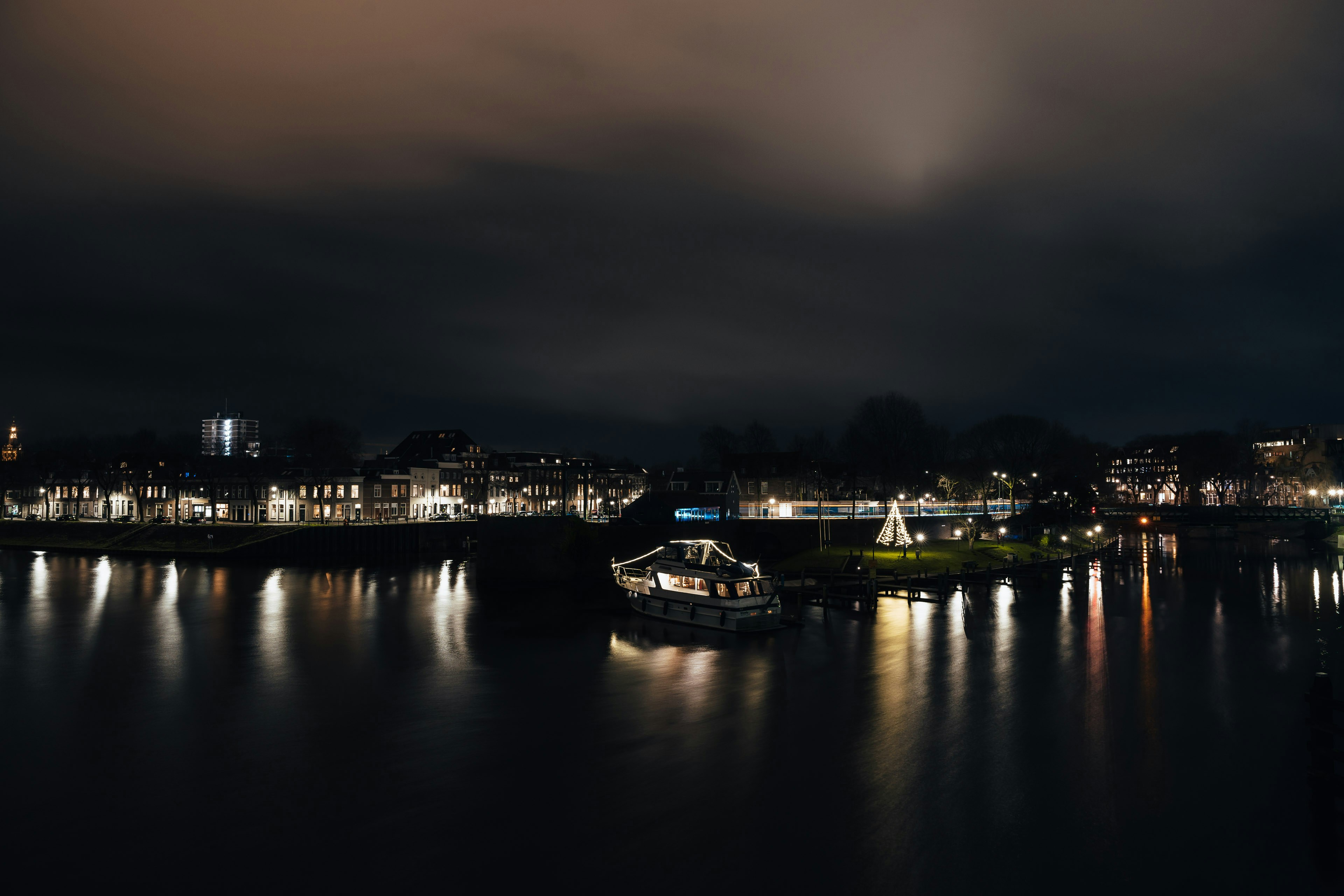 a boat floating on top of a river at night