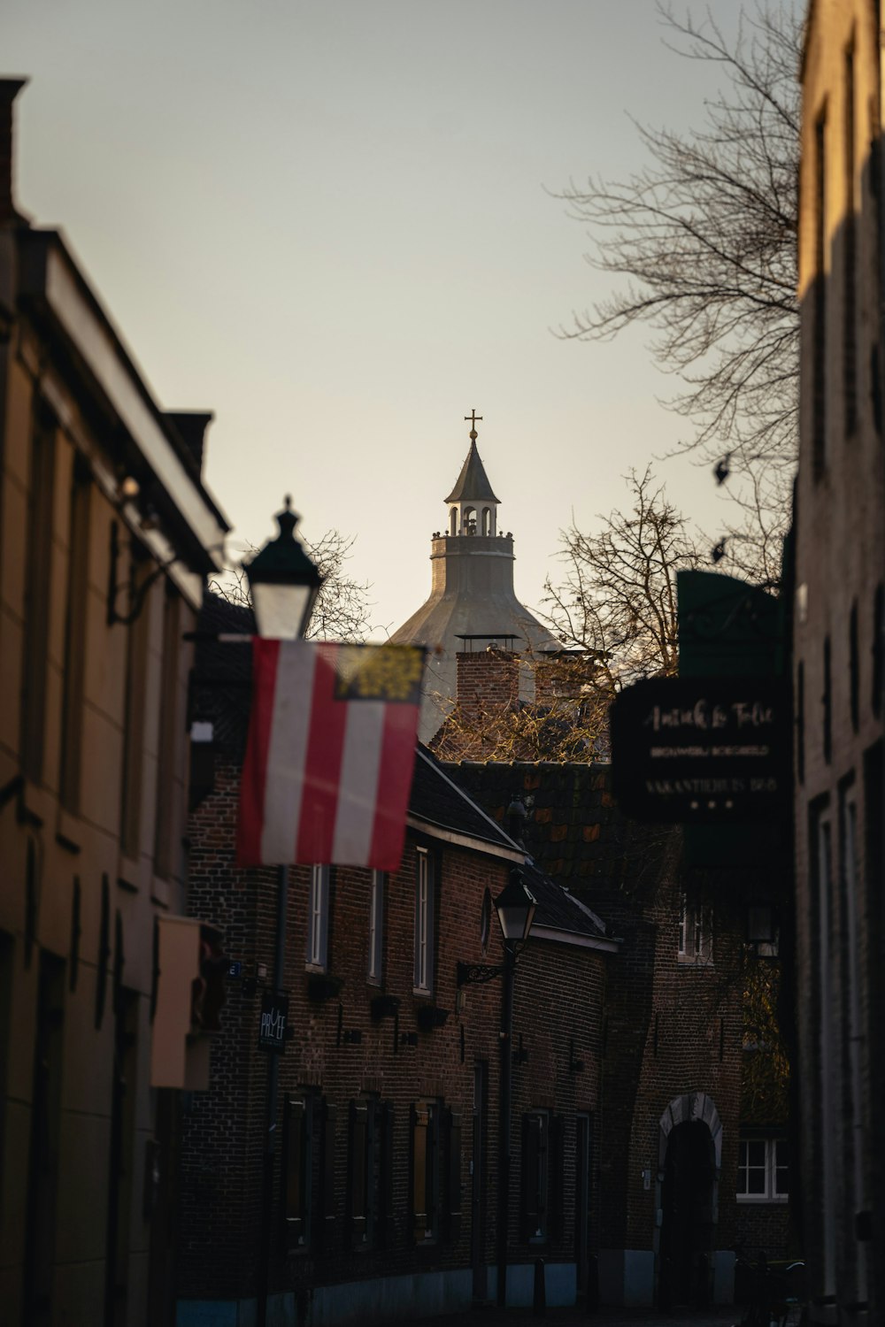 a flag flying in front of a building with a steeple