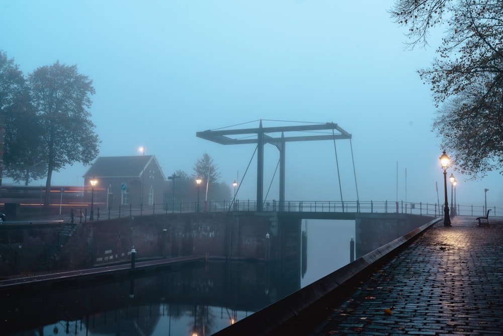 a foggy river with a bridge in the distance
