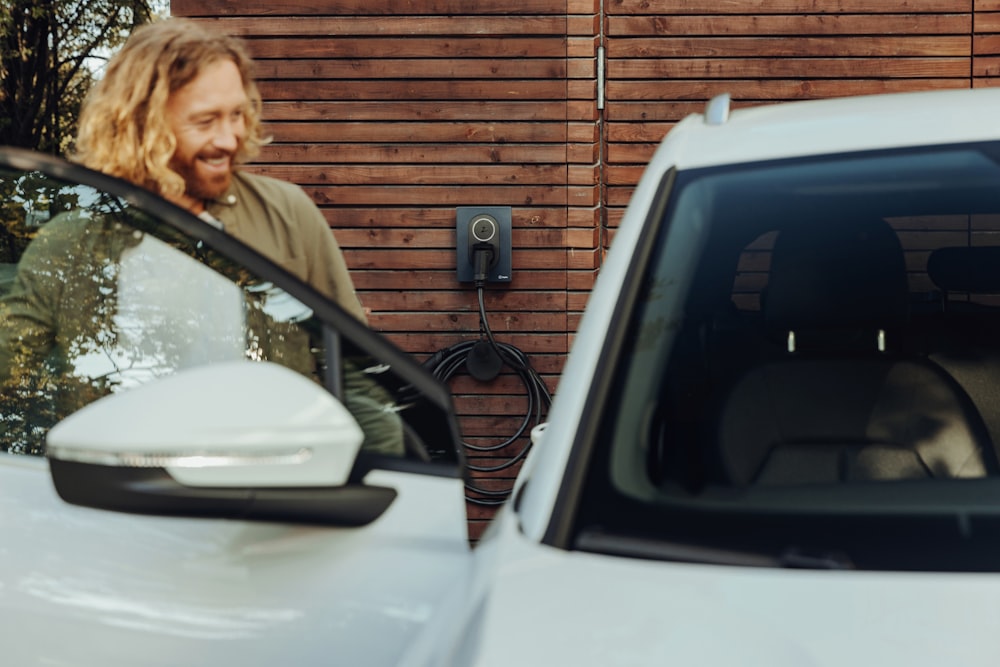 a man standing next to a white car