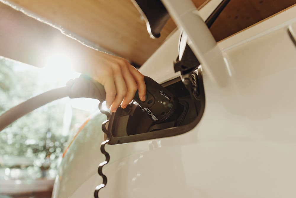 a person pumping gas into a car at a gas station