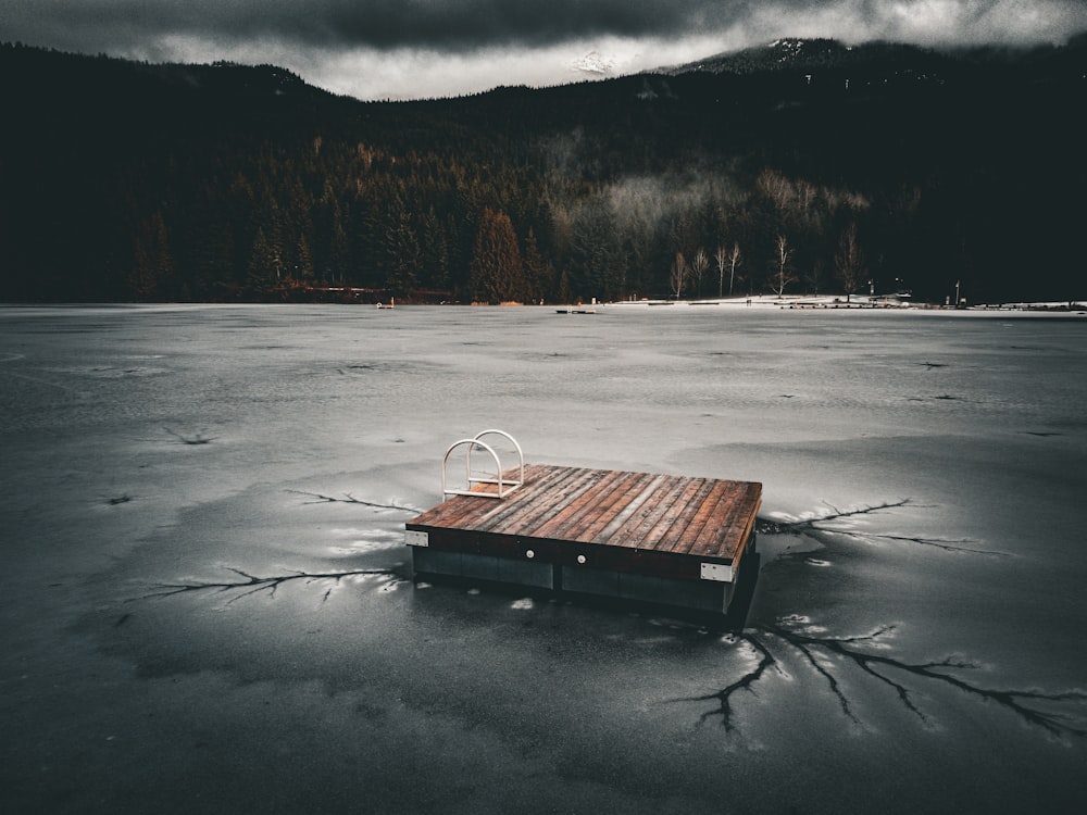 a wooden dock sitting on top of a frozen lake