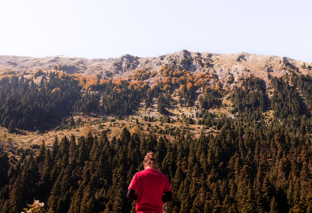 a man standing on top of a lush green hillside