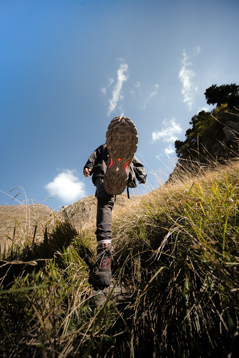 a person walking up a hill with a backpack