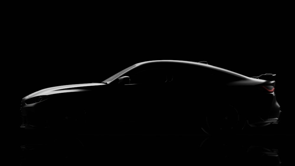 a car is shown in the dark on a black background