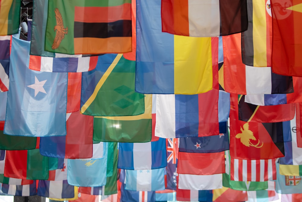 a bunch of flags hanging from a pole