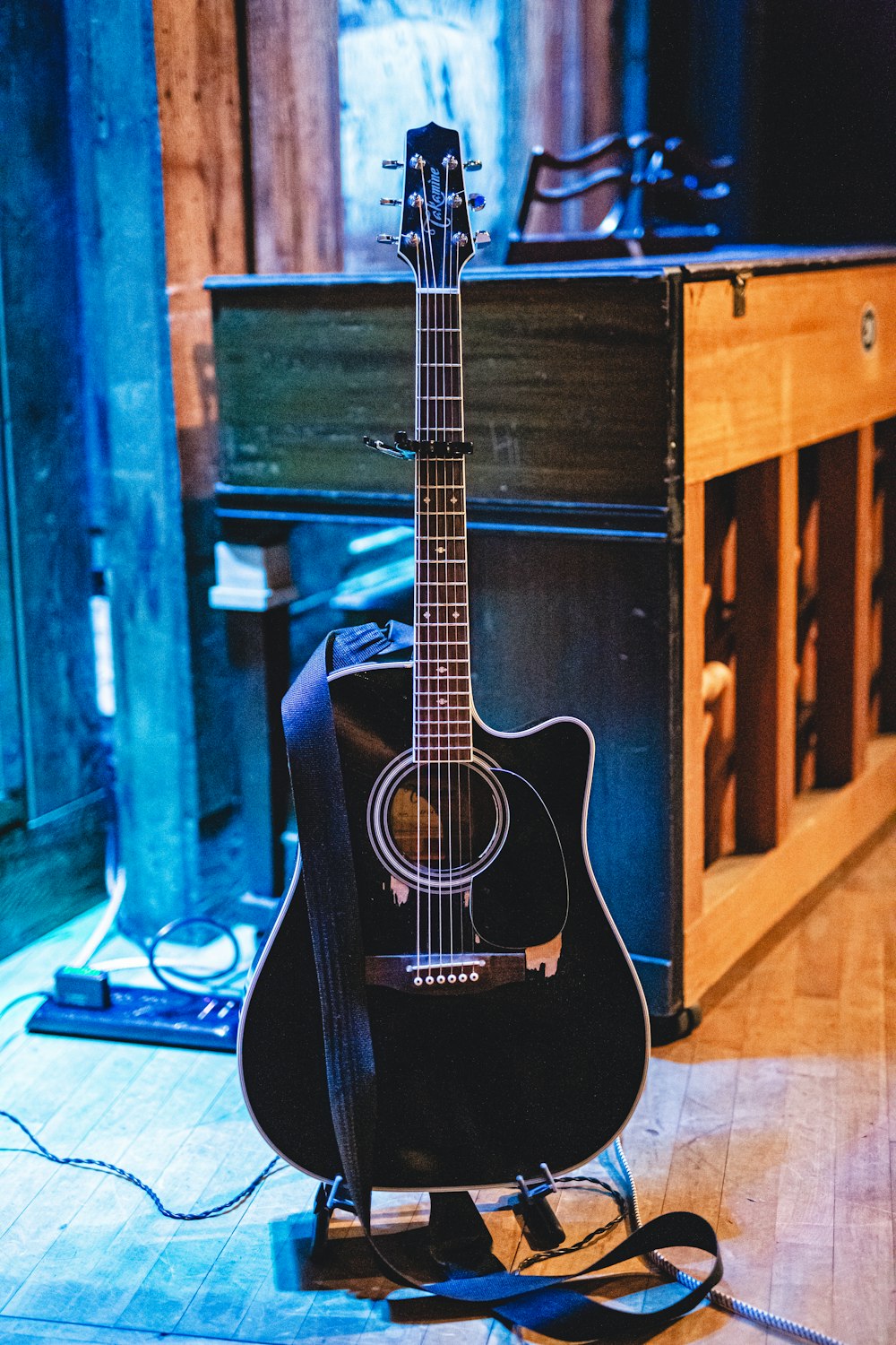 a guitar sitting on top of a hard wood floor