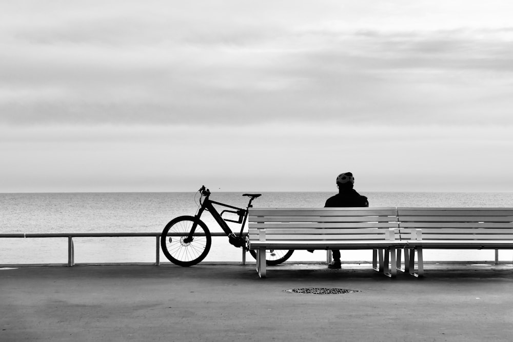 a man sitting on a bench next to a bike