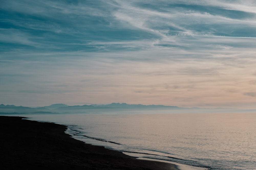 a person walking on a beach near the ocean