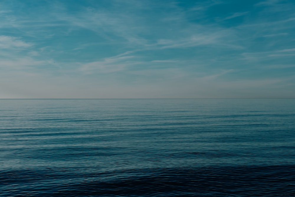 a large body of water sitting under a blue sky