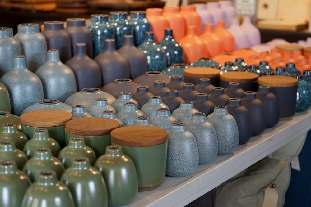 many different colored vases are on a shelf