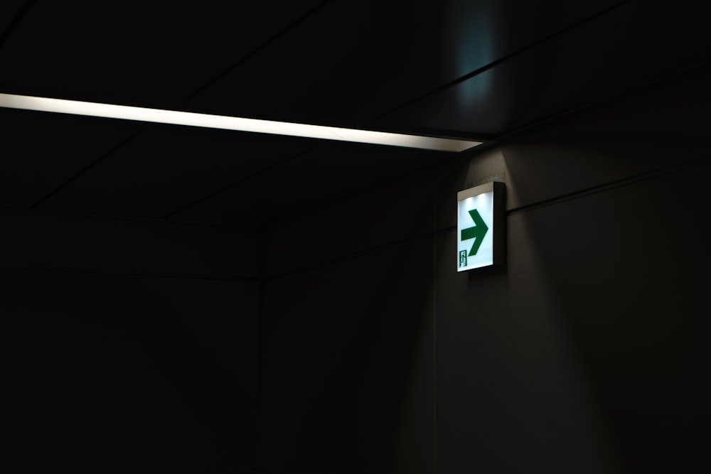 a dark room with a green sign on the wall