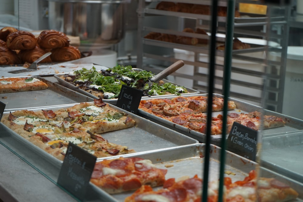 a display case filled with lots of different types of pizza