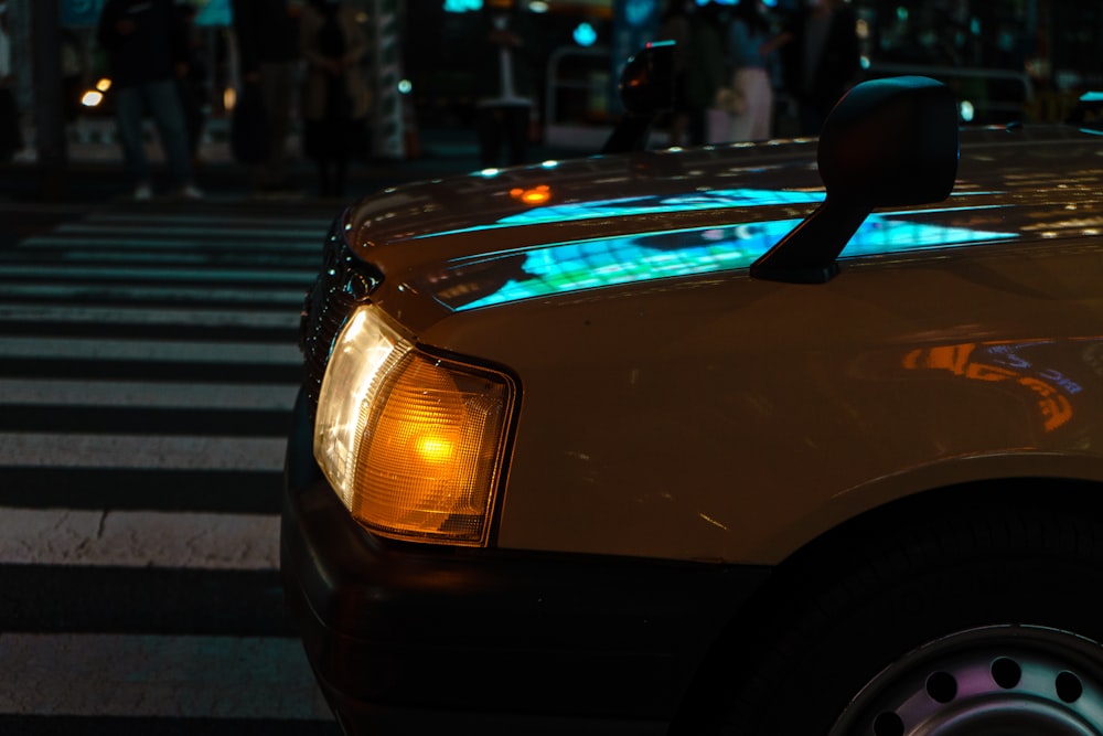 a taxi cab is stopped at a crosswalk at night