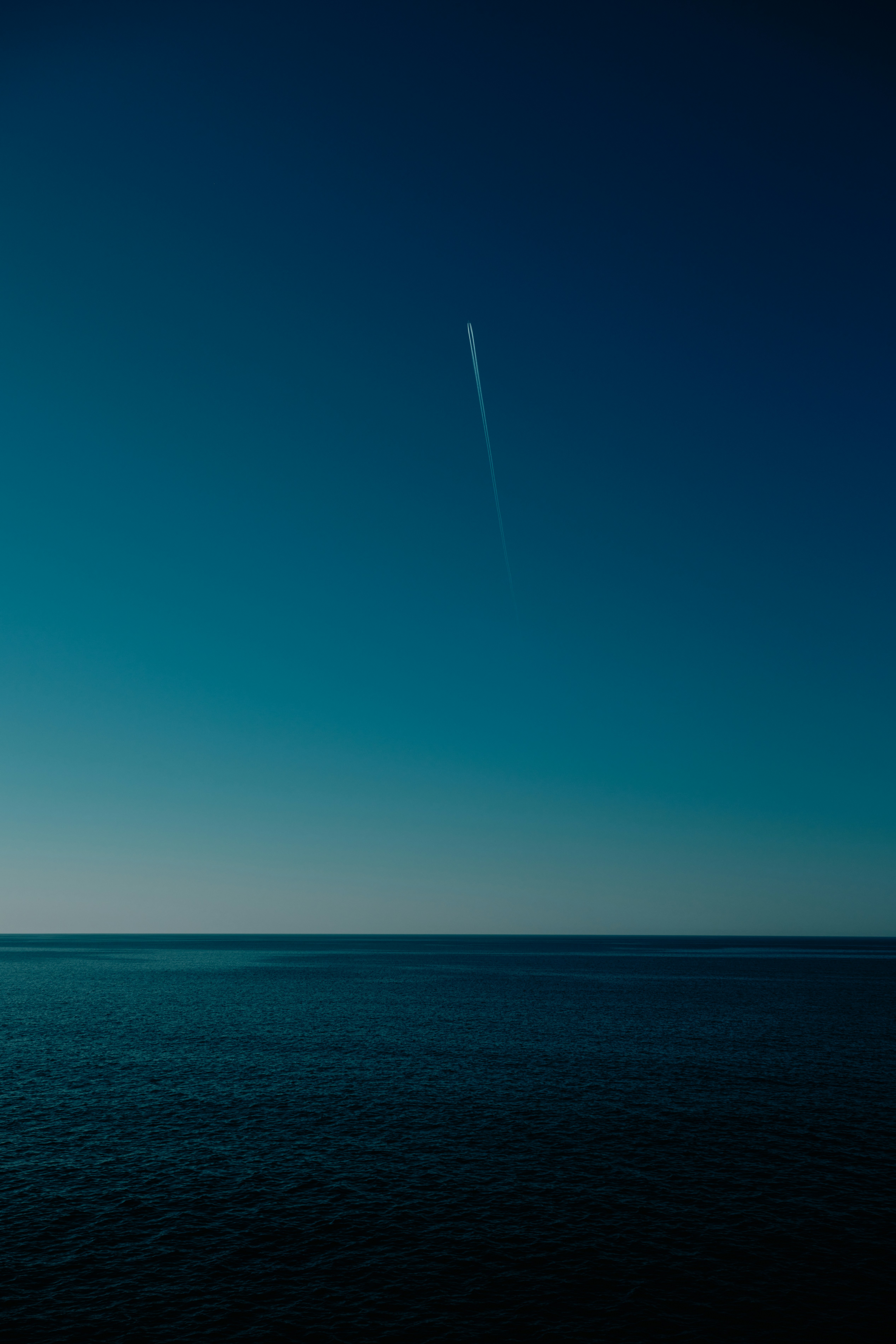 an airplane flying over the ocean on a clear day
