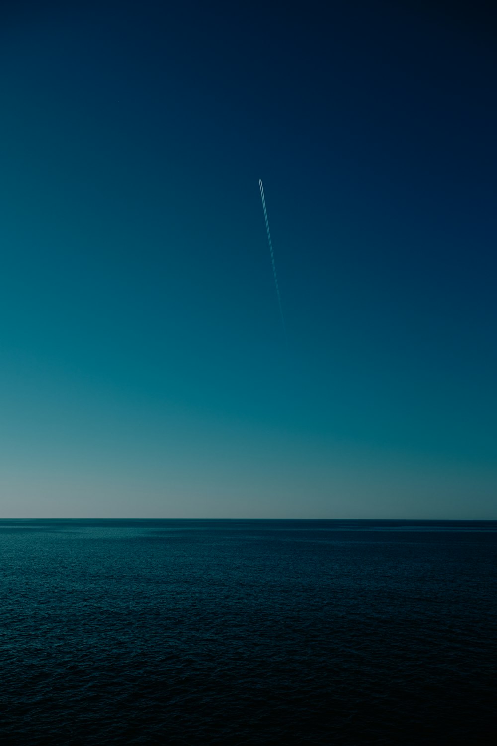 an airplane flying over the ocean on a clear day