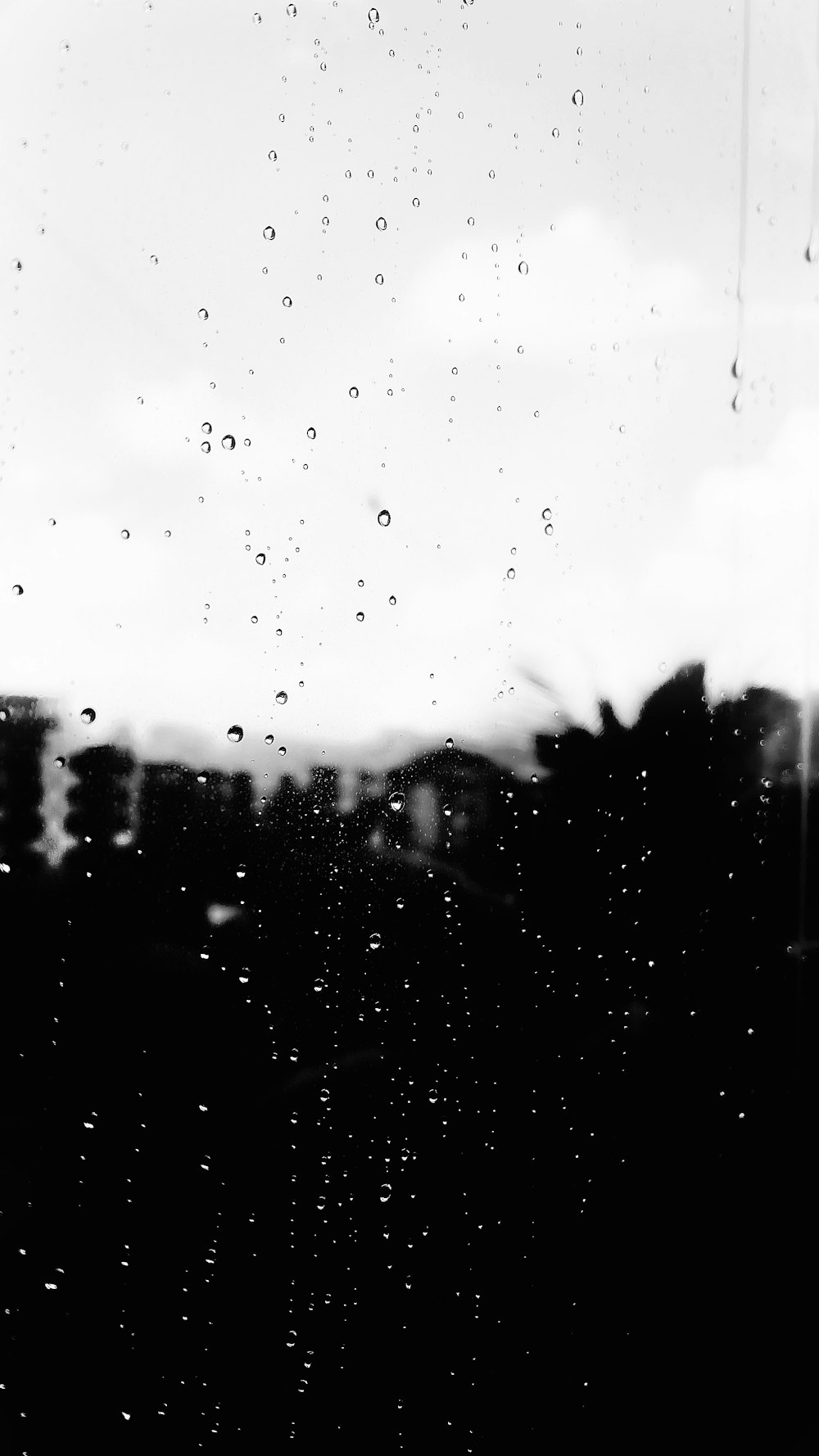 a black and white photo of rain drops on a window