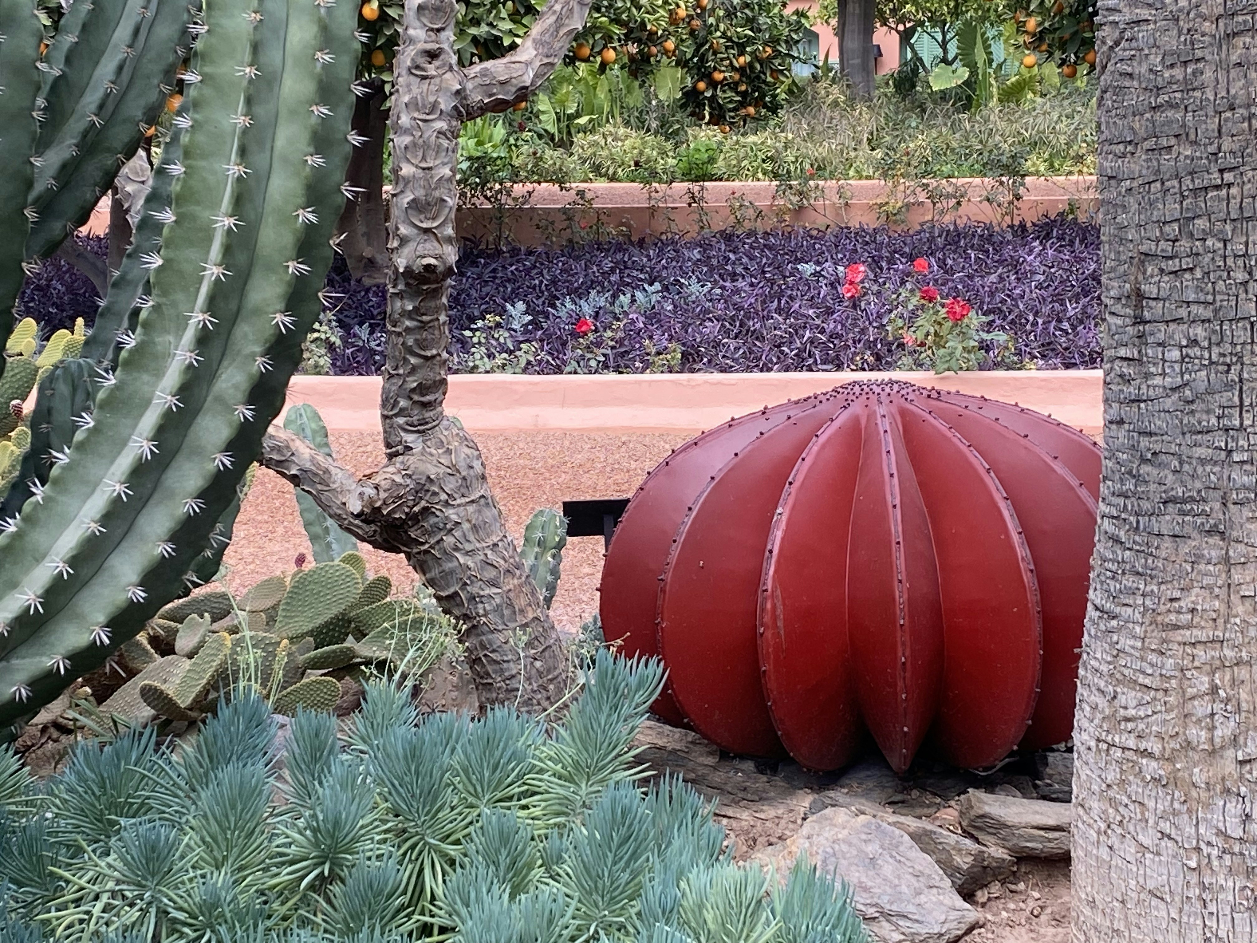 a large red ball sitting in the middle of a garden