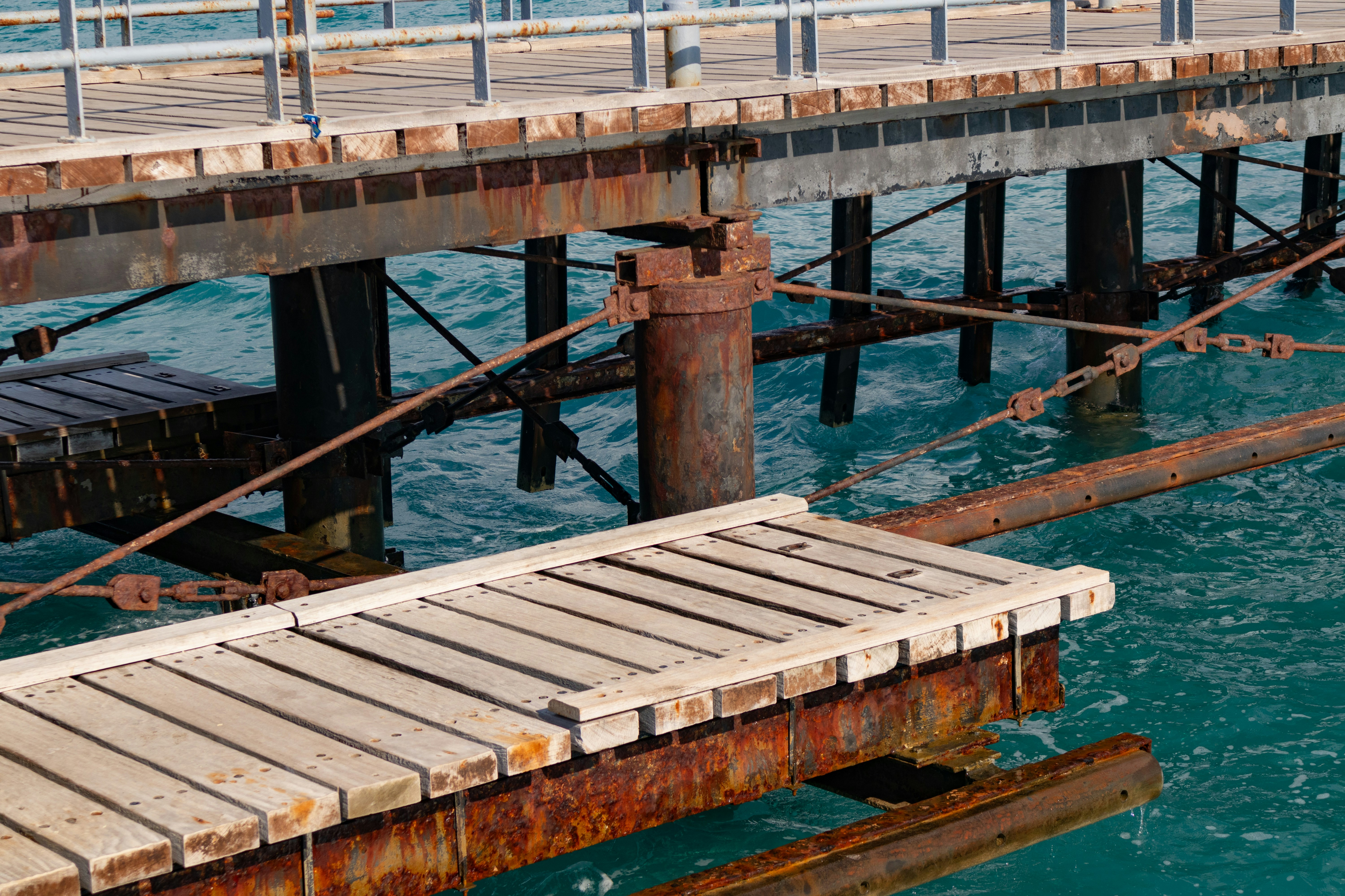 A professional marine construction team carefully installing new, treated wooden pilings for a dock foundation, showcasing precision and safety - boat dock repair