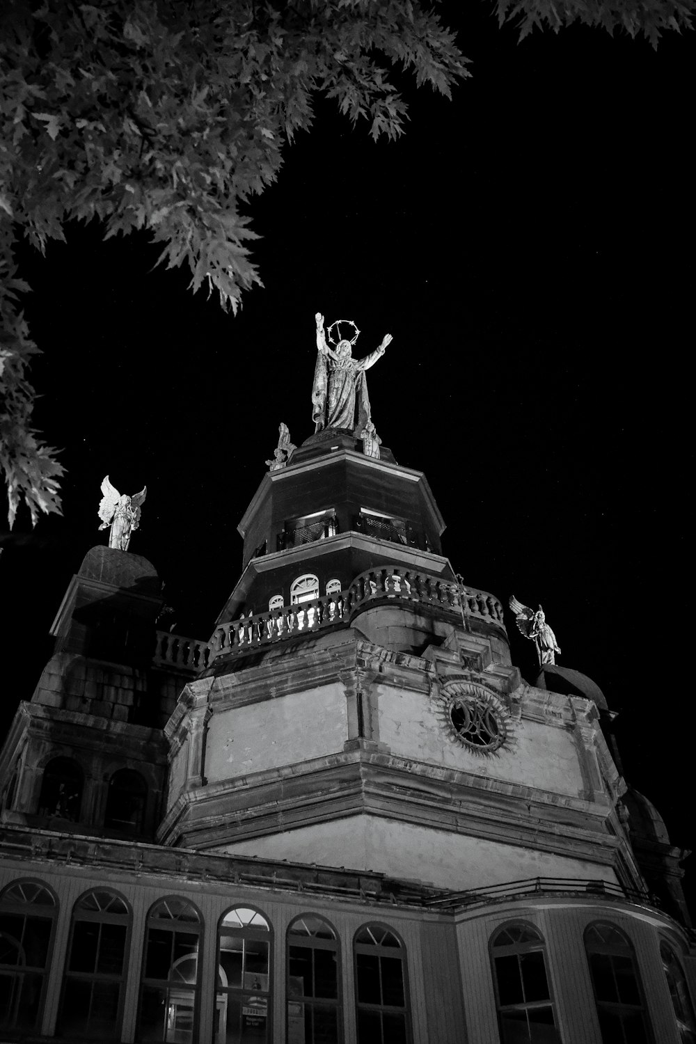 Una foto en blanco y negro de una estatua en la parte superior de un edificio