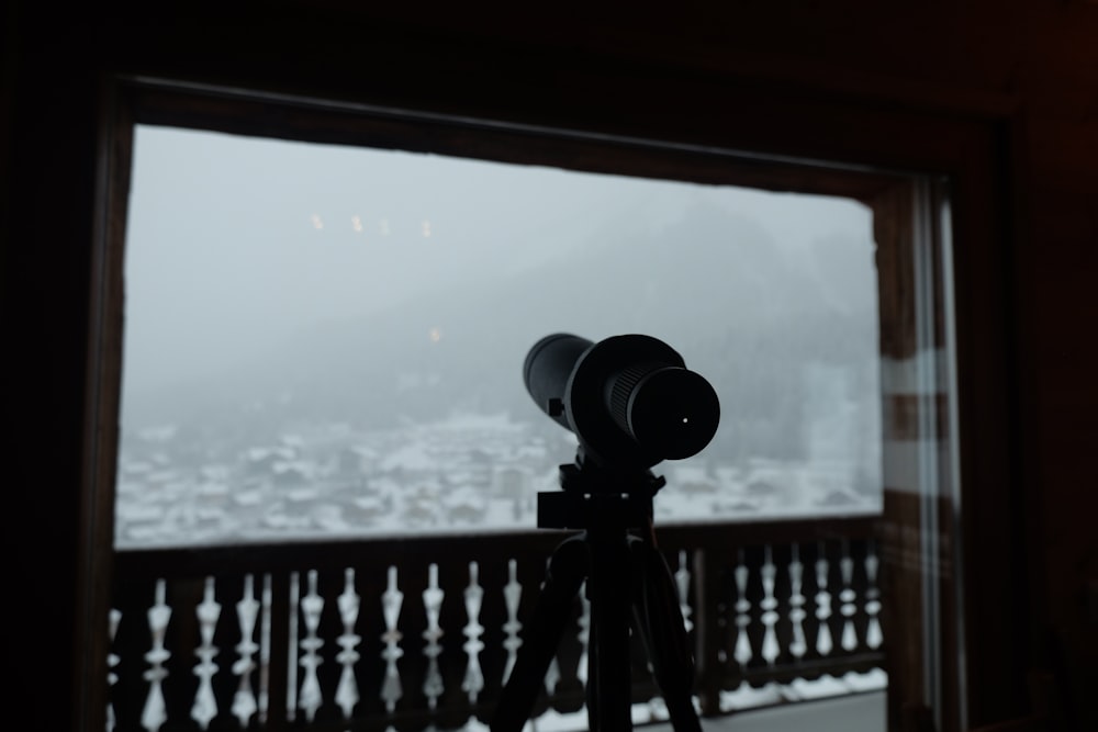 a camera on a tripod in front of a window
