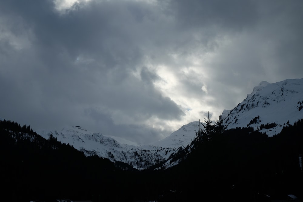 una montagna coperta di neve sotto un cielo nuvoloso