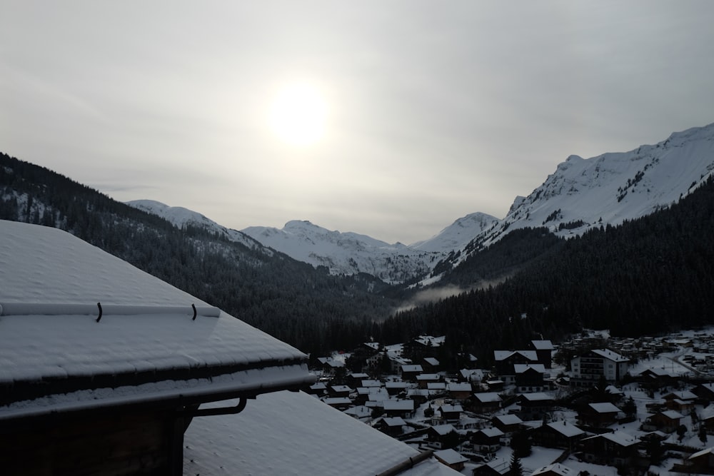 a view of a village in the mountains covered in snow