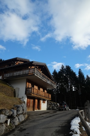 a building with a balcony and a car parked in front of it