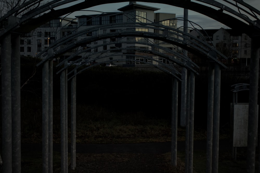 a row of metal poles with a building in the background