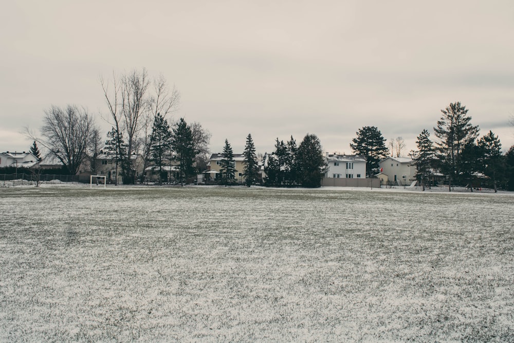 a snow covered field with a house in the background