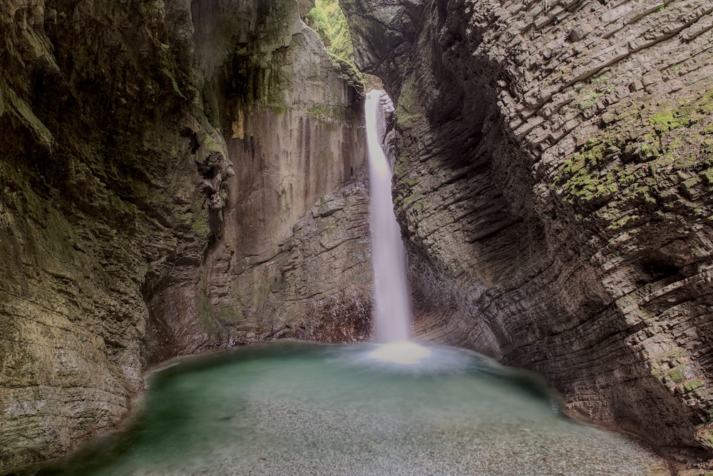 a small waterfall in the middle of a canyon