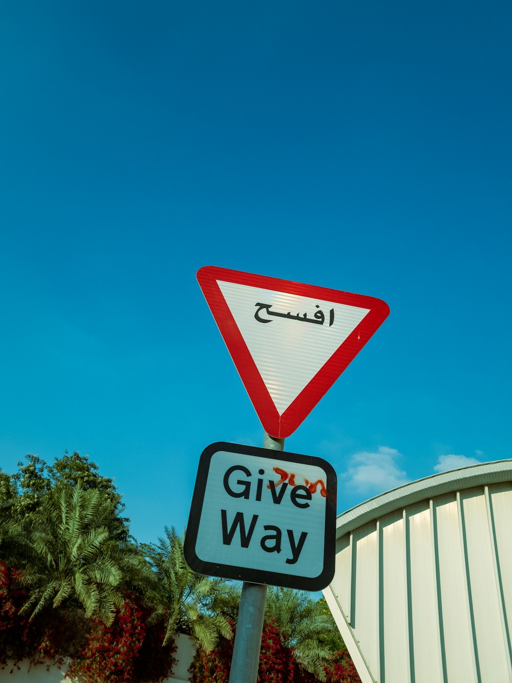 a red and white street sign sitting on top of a metal pole